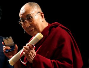 Tibet's exiled spiritual leader the Dalai Lama poses after receiving honorary citizenship of the city of Milan at the Arcimboldi theater in Milan